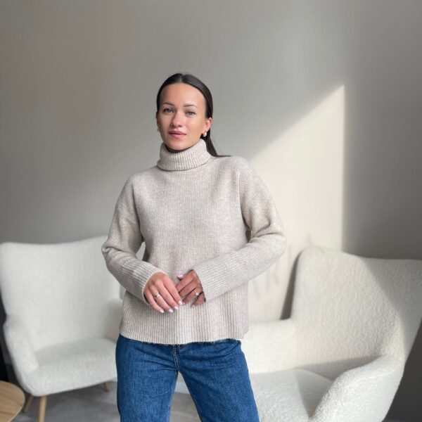 Kreminės spalvos megztinis aukštu kaklu