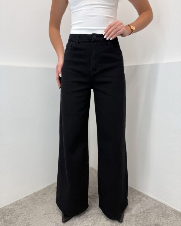 Juodi tamprūs džinsai aukštesnėms moterims